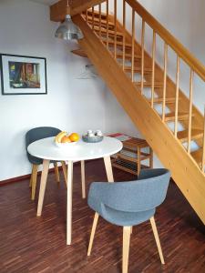 a table and chairs in a room with a staircase at Ferienwohnung Zum Strandvoigt in Sassnitz