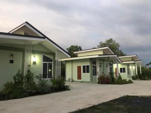 a house with green and white at ออมทรัพย์ รีสอร์ต in Ban Lam Ta Sao Tai
