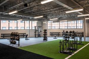 a gym with lots of equipment and a green carpet at The Warehouse Hotel at Champion Mill in Hamilton