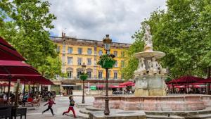 una fuente en una plaza con gente caminando por un edificio en Le T2 Chic !, en Carcassonne