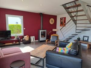 ein Wohnzimmer mit einem Sofa und einer Treppe in der Unterkunft Maison traditionnelle et moderne avec vue mer in Tréffiagat