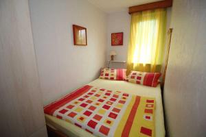 a small bedroom with a bed with a colorful blanket at Ferienhaus Mattke in Sassnitz