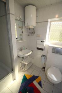 a white bathroom with a sink and a toilet at Ferienhaus Mattke in Sassnitz