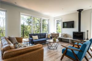 a living room with two couches and a tv at Chalet Alpine by Tremblant Platinum in La Conception