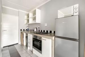 a kitchen with a refrigerator and a stove top oven at Lea's Furnished Apartments - Dainfern in Sandton