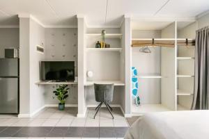 a bedroom with a bed and a desk and a television at Lea's Furnished Apartments - Dainfern in Sandton