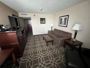 Merriam的住宿－Hotel Lotus Kansas City Merriam，一间配备有沙发及电视的酒店客房