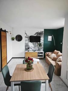 a living room with a table and a couch at Calais Plage-Gare Appartement élégant tout équipé in Calais