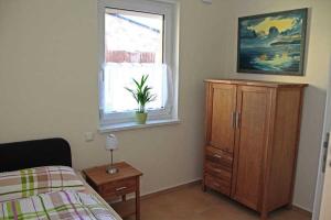 ein Schlafzimmer mit einem Bett, einer Kommode und einem Fenster in der Unterkunft Ferienhaus Frieda in Sagard