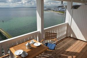 a table and chairs on a porch with a view of the ocean at Fürstenhof - Ferienwohnung 403 in Sassnitz