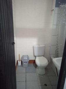 a white bathroom with a toilet and a sink at DEPARTAMENTO CON 3 DORMITORIOS in Huánuco