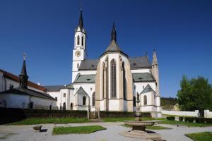 duży biały kościół z wieżą zegarową w obiekcie Hotel Šumava w mieście Vyšší Brod