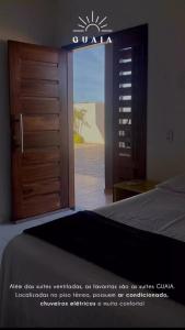 a bedroom with a door open to a bedroom with a bed at POUSADA SOLAR DOS MOREIRAS in Guajiru