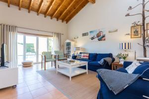 een woonkamer met een blauwe bank en een tafel bij Pita's House - Villa Sagres 2 in Sagres