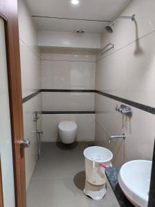 a bathroom with a toilet and a sink at HOTEL SAHYOG & ROOMS in Surat