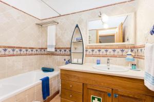 a bathroom with a tub and a sink and a mirror at Pita's House - Villa Sagres 2 in Sagres