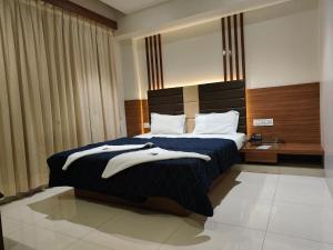 a hotel room with a bed with towels on it at HOTEL SAHYOG & ROOMS in Surat