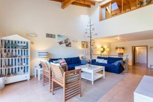 een woonkamer met een blauwe bank en een tafel bij Pita's House - Villa Sagres 2 in Sagres