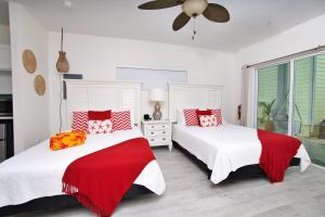 two beds in a bedroom with red and white pillows at The No Problem at Cottages in Sand Bluff