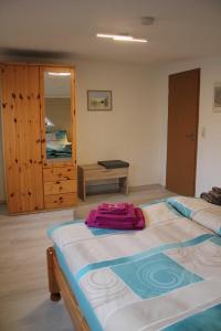 ein Schlafzimmer mit einem großen Bett und einem Holzschrank in der Unterkunft Ferienhaus Penno in Sassnitz