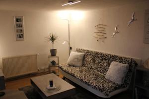 ein Wohnzimmer mit Sofa und Vögeln an der Wand in der Unterkunft Ferienhaus Penno in Sassnitz