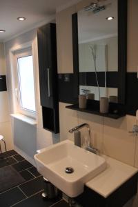 ein Badezimmer mit einem weißen Waschbecken und einem Spiegel in der Unterkunft Ferienhaus Penno in Sassnitz