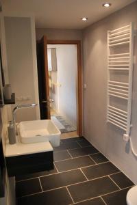 La salle de bains est pourvue d'un lavabo, de toilettes et d'un miroir. dans l'établissement Ferienhaus Penno, à Sassnitz