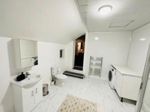 a white bathroom with a sink and a toilet at Bespoke 2 Bedroom Apt Derby City in Derby