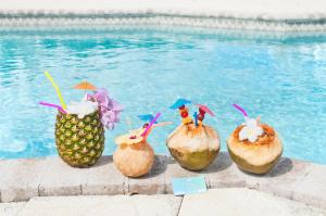 a group of coconuts with drinks on them next to a swimming pool at The Sand Dollar at Cottages in Sand Bluff