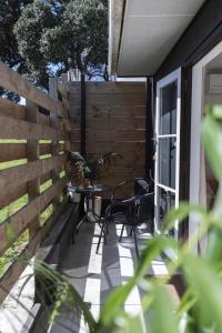 a patio with a table and chairs and a fence at Mount Beach Villa in Mount Maunganui