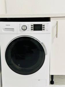 a white microwave sitting on top of a washing machine at Bespoke 2 Bedroom Apt Derby City in Derby