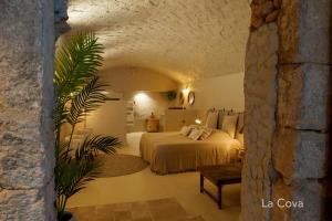 - une chambre avec un lit et un mur en pierre dans l'établissement Cal Mestre Casa Rural, à Avinyonet