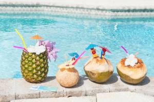 a group of coconuts withanas and cocktails on a ledge by a pool at The Turtle Nest at Cottages in Sand Bluff