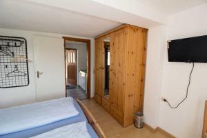 a bedroom with a bed and a flat screen tv at Ferienzimmer zum Försterberg in Hagen