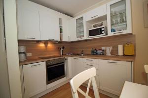 a kitchen with white cabinets and a stove top oven at Villa Seeblick Apartment 307 in Sassnitz