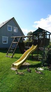 einen Spielplatz mit Rutsche und Spielstruktur in der Unterkunft Ferienwohnung BoddenBlick in Polchow