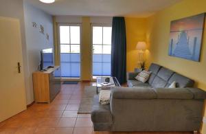 a living room with a couch and a television at Ferienwohnung Kranichglück in Neddesitz