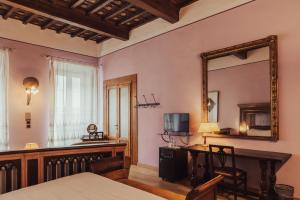1 dormitorio con escritorio, espejo y mesa en II Guelfo Bianco, en Florencia