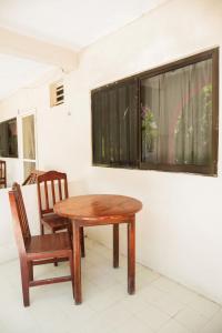 a wooden table and a chair and a window at Hotel Los Arcos Holbox in Holbox Island