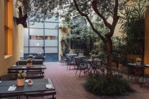 a patio with tables and chairs and a tree at II Guelfo Bianco in Florence