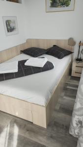 un grande letto con lenzuola bianche e cuscini neri di 86 Nicolea Labis Coresi a Braşov