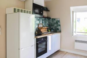 a kitchen with a white refrigerator and a stove at Cozy accommodation 7 minutes from Paris's center in Asnières-sur-Seine