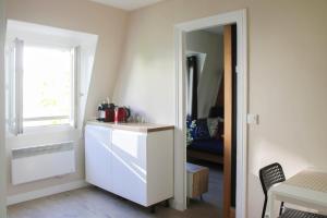 a kitchen with a white refrigerator and a window at Cozy accommodation 7 minutes from Paris's center in Asnières-sur-Seine