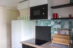 a kitchen with a microwave above a stove at Cozy accommodation 7 minutes from Paris's center in Asnières-sur-Seine