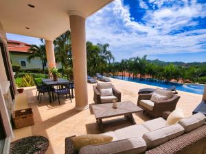 a patio with a couch and chairs and a pool at Pearl Court 1111 at Pristine Bay in French Harbour