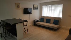 a living room with a couch and a table and a television at Central Windsor 2 bedroom flat with free parking in Windsor