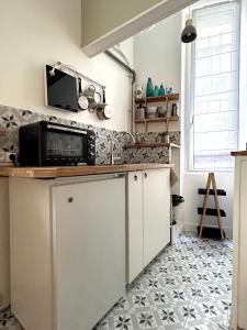 uma cozinha com um micro-ondas em cima de um balcão em Lovely studio Crimee em Paris