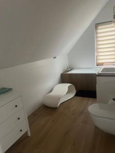 ein weißes Bad mit einem WC und einem Waschbecken in der Unterkunft Dom w Chmielnie Na Wzgórzu in Chmielno