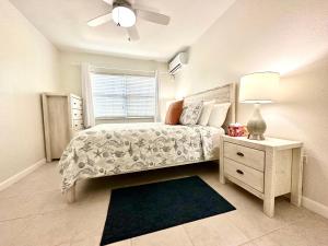 a bedroom with a bed and a nightstand and a window at Snug Harbour View Condo #2 in George Town