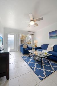 a living room with blue couches and a table at Snug Harbour View Condo #2 in George Town